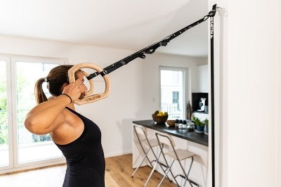 Women training arms with trx fitness straps in the gym doing push ups train  upper body chest shoulders pecs triceps. Stock Photo